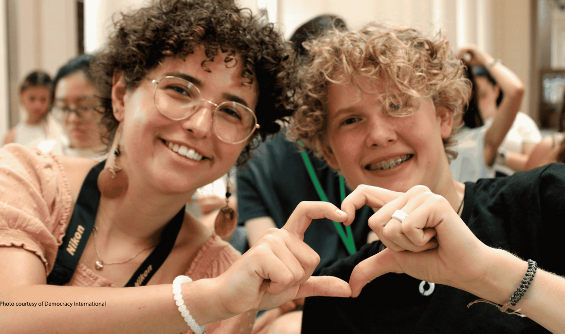 Photo of 2 young people shaping heart with their hands